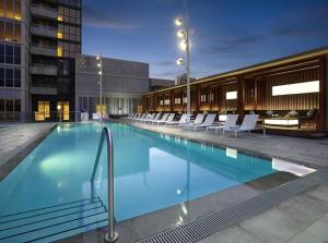 a large swimming pool with white chairs in a building at Luxury 1 BR and Den Near CN Tower in Toronto