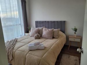 a bed with two towels on it in a bedroom at Departamento 1D central in Chillán