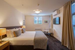 a hotel room with a large bed and a desk at Marina Apartments - Element Escapes in Queenstown