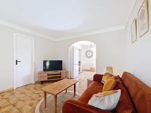 a living room with a brown couch and a tv at Rez de villa de charme à Montauroux près du lac Saint-Cassien, 2 chambres, jardin privatif - FR-1-779-16 in Montauroux