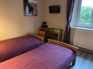 ein Zimmer mit zwei Betten und einem Schreibtisch und einem Fenster in der Unterkunft Séjour paisible dans la campagne de Mont-l'Étroit, proche de sites historiques - FR-1-584-381 in Mont-lʼÉtroit