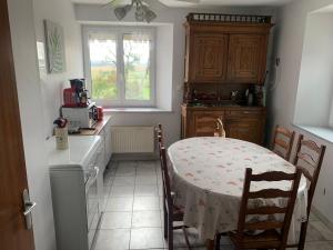 eine Küche mit einem Tisch und einem Tisch und Stühlen in der Unterkunft Séjour paisible dans la campagne de Mont-l'Étroit, proche de sites historiques - FR-1-584-381 in Mont-lʼÉtroit