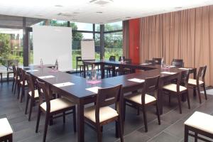 una gran sala de conferencias con mesas y sillas en Logis Hôtel Terre de Loire en Belleville-sur-Loire