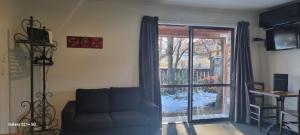 a living room with a couch and a sliding glass door at Star Cottages in Lake Tekapo