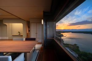 a room with a large window with a view of the water at Kashikojima Hojoen in Shima