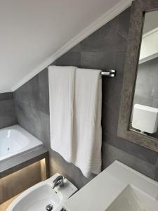 a bathroom with a sink and a mirror and towels at Spazio Oliveira Sparone in Sparone