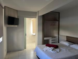 a bedroom with a bed and a tv in it at Kris Hotel in Petrolina