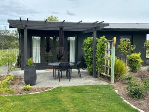 een patio met een tafel en een pergola bij Puketapu Orchard Retreat in Napier +1 foto