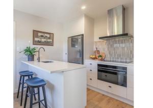 een keuken met witte kasten en blauwe krukken bij Puketapu Orchard Retreat in Napier