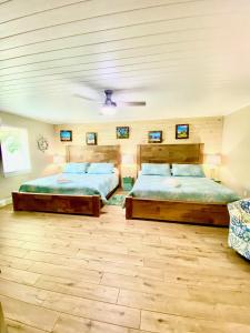 two beds in a bedroom with wooden floors at Oak Cottages 4 in Rockport