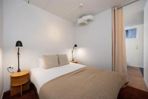 a white bedroom with a bed and a window at JAPAVISTA r4 in Tokyo