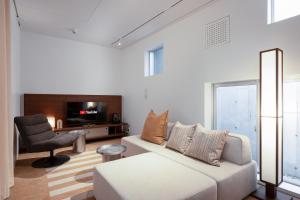 a living room with a white couch and a chair at JAPAVISTA r4 in Tokyo