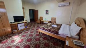 a hotel room with a bed and a tv and a room at Selbe Oyu in Ulaanbaatar