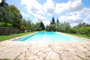 duży basen na dziedzińcu z kamiennym patio w obiekcie Casina w mieście Gaiole in Chianti