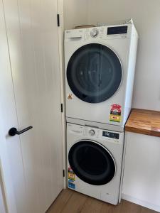 een wasmachine en een droger in de keuken bij Puketapu Orchard Retreat in Napier