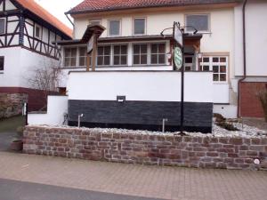 a house with a clock on top of a brick wall at Zur Alten Fuldaschleife in Guxhagen