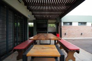 a wooden table and benches on a patio at LA CASITA in Roldán