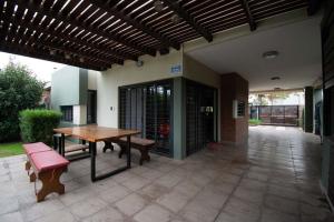 an outdoor patio with a wooden table and benches at LA CASITA in Roldán