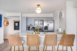 Una cocina con un mostrador y tres sillas. en Newly Renovated San Luis Resort luxury condo, en Galveston