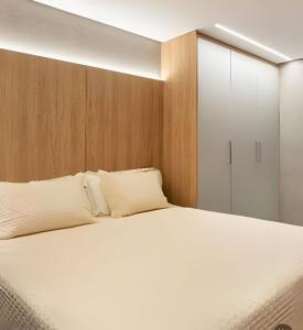 a bedroom with a white bed and a closet at Studio Soberano - O mais luxuoso de CG in Campo Grande