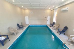 - une piscine dans une pièce entourée de chaises dans l'établissement Grace HideawayHUGESleeps20 Pool Hot Tub Games, à Sevierville