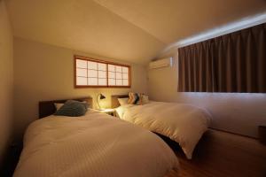 two beds in a room with a window at Nicostay Katsuura Beach in Fukuoka +107 photos