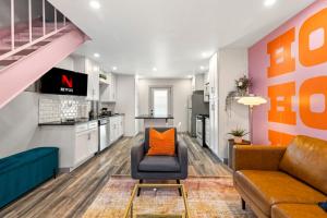 una sala de estar con un sofá y una silla en Ladybird Pink Palace SoCo Dream Townhome!, en Austin