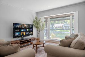 - un salon avec deux chaises et une télévision à écran plat dans l'établissement Play and Stay Dallas Home with Gym Gameroom and WiFi, à Dallas