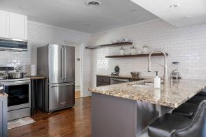 une cuisine avec un réfrigérateur en acier inoxydable et un comptoir dans l'établissement Play and Stay Dallas Home with Gym Gameroom and WiFi, à Dallas