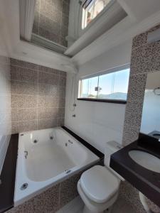 Un baño con bañera, inodoro y lavabo. en MDQ Hostel Paraty, en Paraty