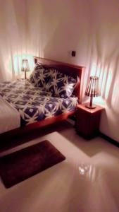 a bedroom with a bed with two lamps on it at Paradise villa Aluthgama in Nikawatawana