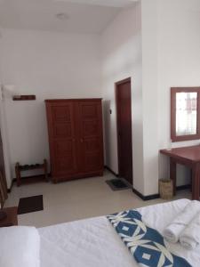 a bedroom with a bed and a wooden door at Paradise villa Aluthgama in Nikawatawana