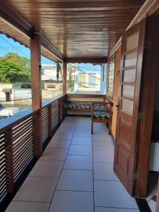un balcón vacío con banco y ventana en MDQ Hostel Paraty, en Paraty