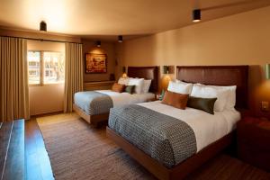 陶斯Hotel Willa的有两张床和一扇窗户的酒店房间