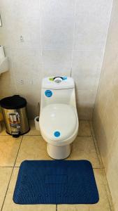 a bathroom with a toilet with a blue rug at Cerca de todo en La Union in La Unión