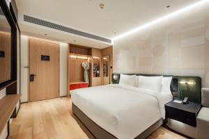 a bedroom with a large white bed and a television at EVEN Hotel Shanghai Jinqiao by IHG in Shanghai