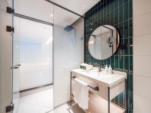 a bathroom with a sink and a mirror at EVEN Hotel Shanghai Jinqiao by IHG in Shanghai