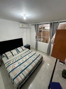 a bedroom with a bed with a colorful comforter at Casa calima in Cali