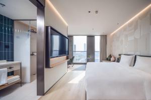 a hotel room with a large bed and a television at EVEN Hotel Shanghai Jinqiao by IHG in Shanghai
