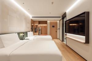 a hotel room with two beds and a flat screen tv at EVEN Hotel Shanghai Jinqiao by IHG in Shanghai