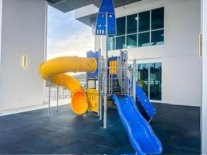 a playground in a building with a yellow slide at AFFT Home Camp - Kota Kinabalu Seaview in Kota Kinabalu