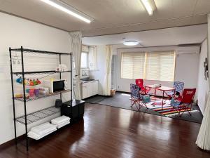 a living room with a table and chairs and a kitchen at Iris in Hakodate