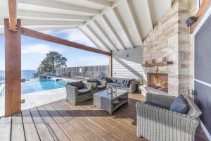un patio con chimenea y piscina en Horizons at Hyams Beach, en Hyams Beach