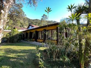 ペトロポリスにあるMansão B@rdô Espaço Gourmet Piscina Petrópolis RJの前にヤシの木がある家