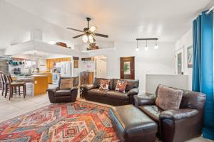 a living room with leather furniture and a kitchen at Lake View, Themed Rooms, King Beds, Fire Pit in Lake Havasu City