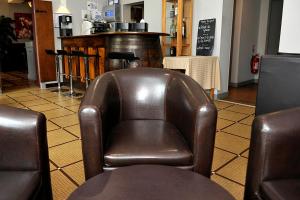 una silla de cuero marrón sentada en una habitación en Le Lion d'Or, en Ingrandes