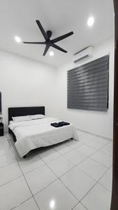 a bedroom with a bed and a ceiling fan at Stay Put by Liza in Jasin
