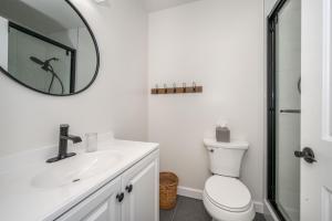 a white bathroom with a sink and a mirror at Historic Ludlow Apt B in Ludlow