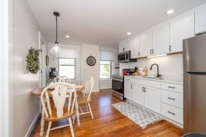 a kitchen with white cabinets and a table and chairs at Historic Ludlow Apt B in Ludlow