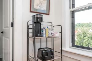 a coffee maker on a stand next to a window at Historic Ludlow Apt B in Ludlow +9 photos